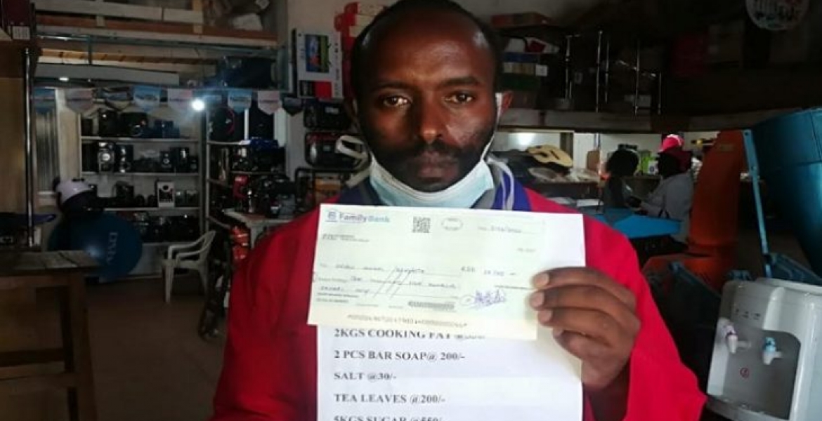 David Wanjohi holds a cheque written to President Uhuru on April 3rd Kenyan Man Writes Sh10,500 Personal Check to President Uhuru for Combating Covid-19